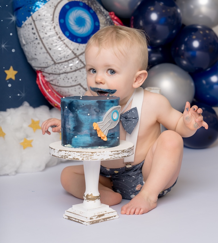 Baby with cake moustache from space themed cake smash by Forest Row photography studio