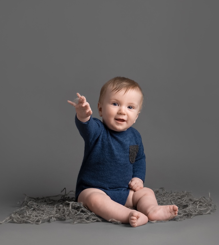 Baby sitting and pointing excitedly by Haywards Heath photographer